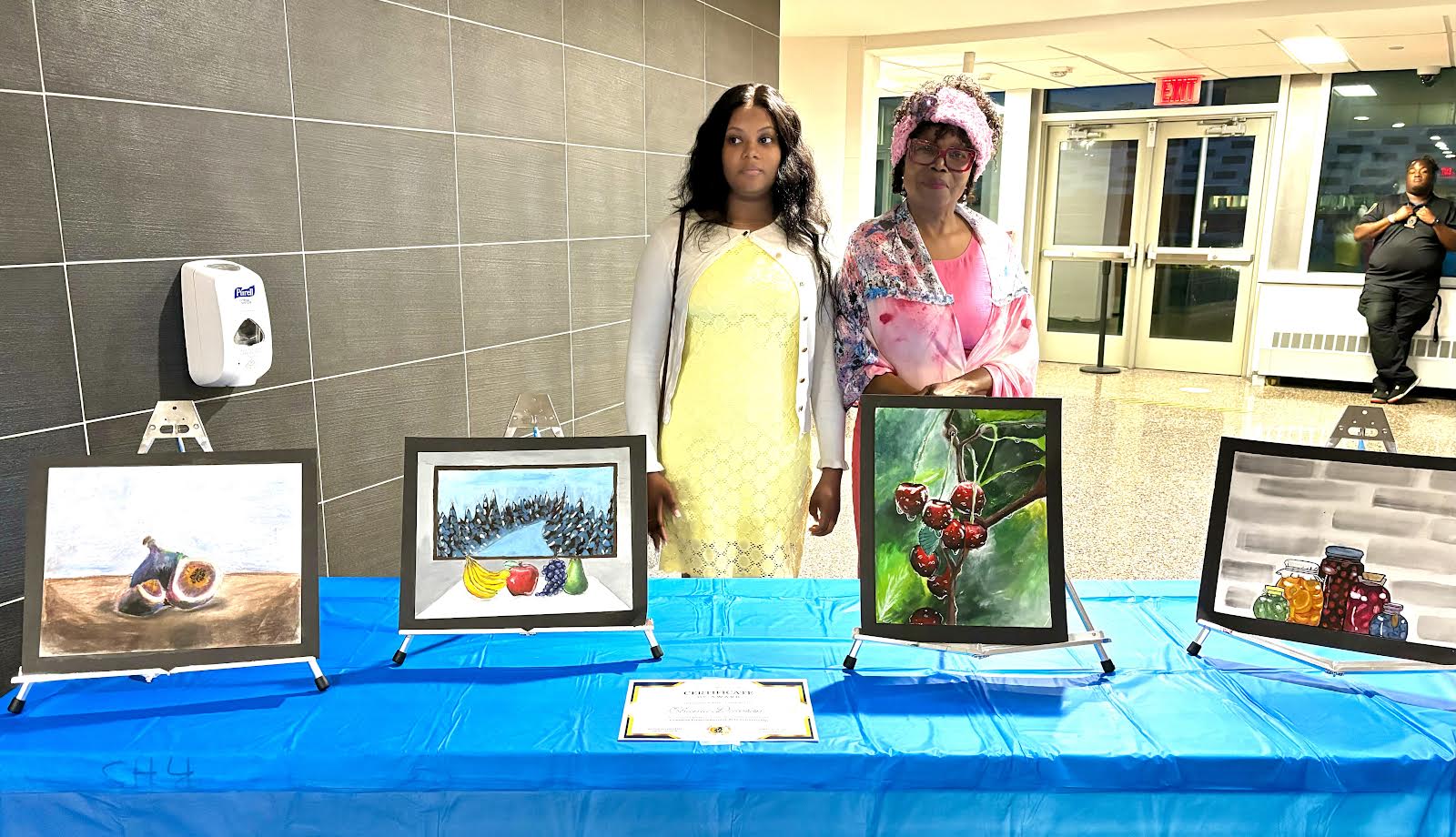 Shania Dawson and Mrs. Cole-Lacy pose behind a display of her winning entry.